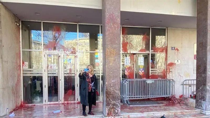 Žena ispred zgrade skupštine Grada Beograda koju je desetine ljudi prethodno gađalo jajima i kesicama sa crvenom bojom