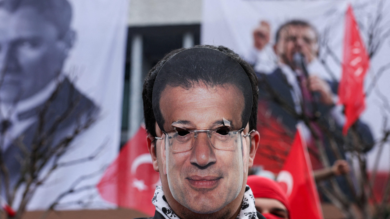 Demonstrant nosi masku sa likom Ekrema Imamoglua 