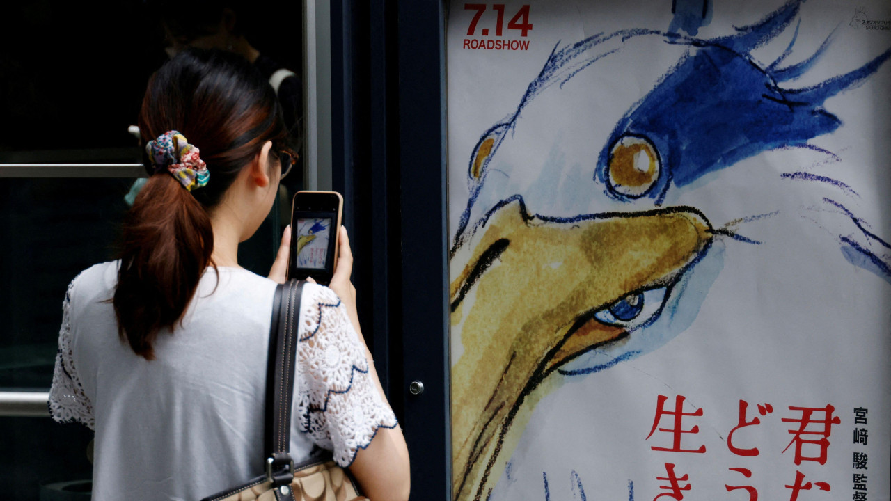 Žena fotografiše poster za film „The Boy and the Heron" 