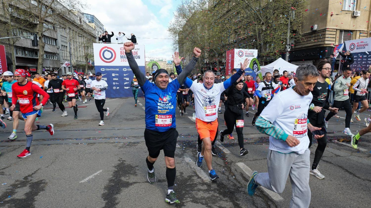 Ljudi gestikuliraju dignutih ruku na početku maratona