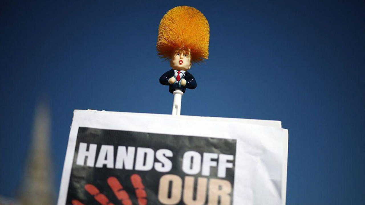 četka za WC sa Trampovim likom i natpis dalje ruke