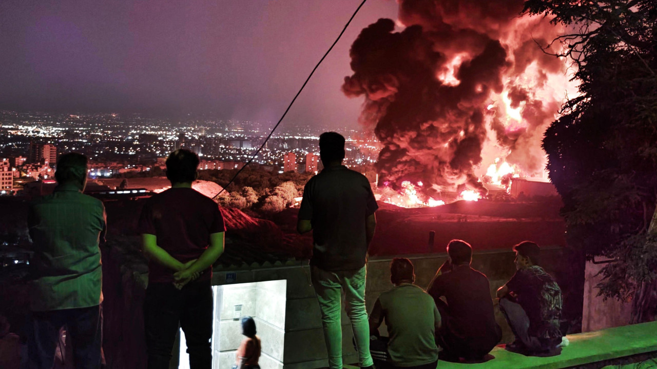Ljudi posmatraju plamen koji se širi iz naftnog skladišta Šahrana u Teheranu 16. juna nakon izraelskog napada