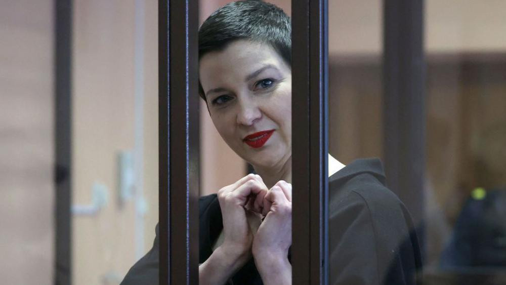 Maria Kolesnikova, the last remaining protest leader still in Belarus, gestures making a heart shape inside the defendants' cage during her verdict hearing on charges of undermining national security, conspiring to seize power and creating an extremist group. Pictured in September 2021