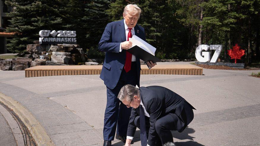 Donald Tramp stoji sa fasciklom papira, britanski premijer se sagnuo da pokupi papire sa poda