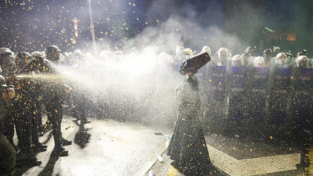 protesti u turskoj, demonstracije u turskoj, demonstrant obučen kao derviš ispred policijskog kordona dok policajci prskaju biber sprej na njega