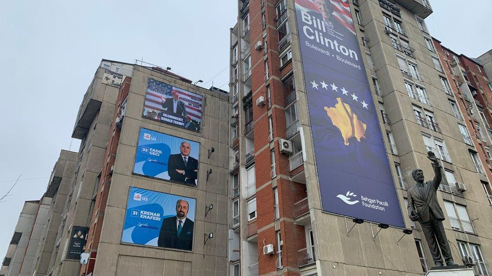 Dva predizborna postera iznad kojih je Donald Tramp, a na zgradi pored je bilbord posvećen Bilu Klintonu, bišvem američkom predsedniku, gde je postavljena i njegova statuta