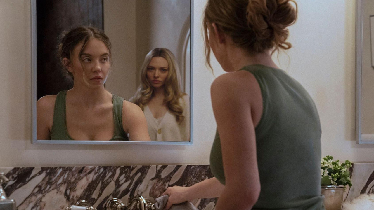 Scena iz filma „Kućna pomoćnica“ prikazuje odraz Sidni Svini u ogledalu. Ona gleda u Amandu Sejfrid, koja se pojavljuje iza nje. Svini nosi zelenu majicu, dok Sejfrid nosi belu bluzu.