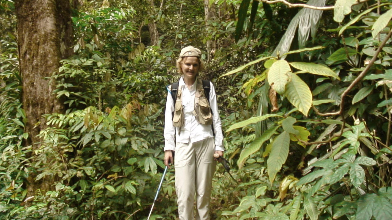 Anet okružena bujnom vegetacijom, sa rancem i planinarskim štapom
