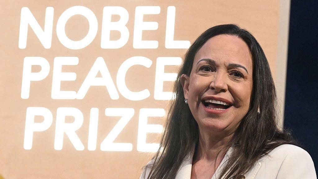 Marija Korina Mačado nosi svetlo odelo i osmehuje se na dodeli Nobelove nagrade za mir.