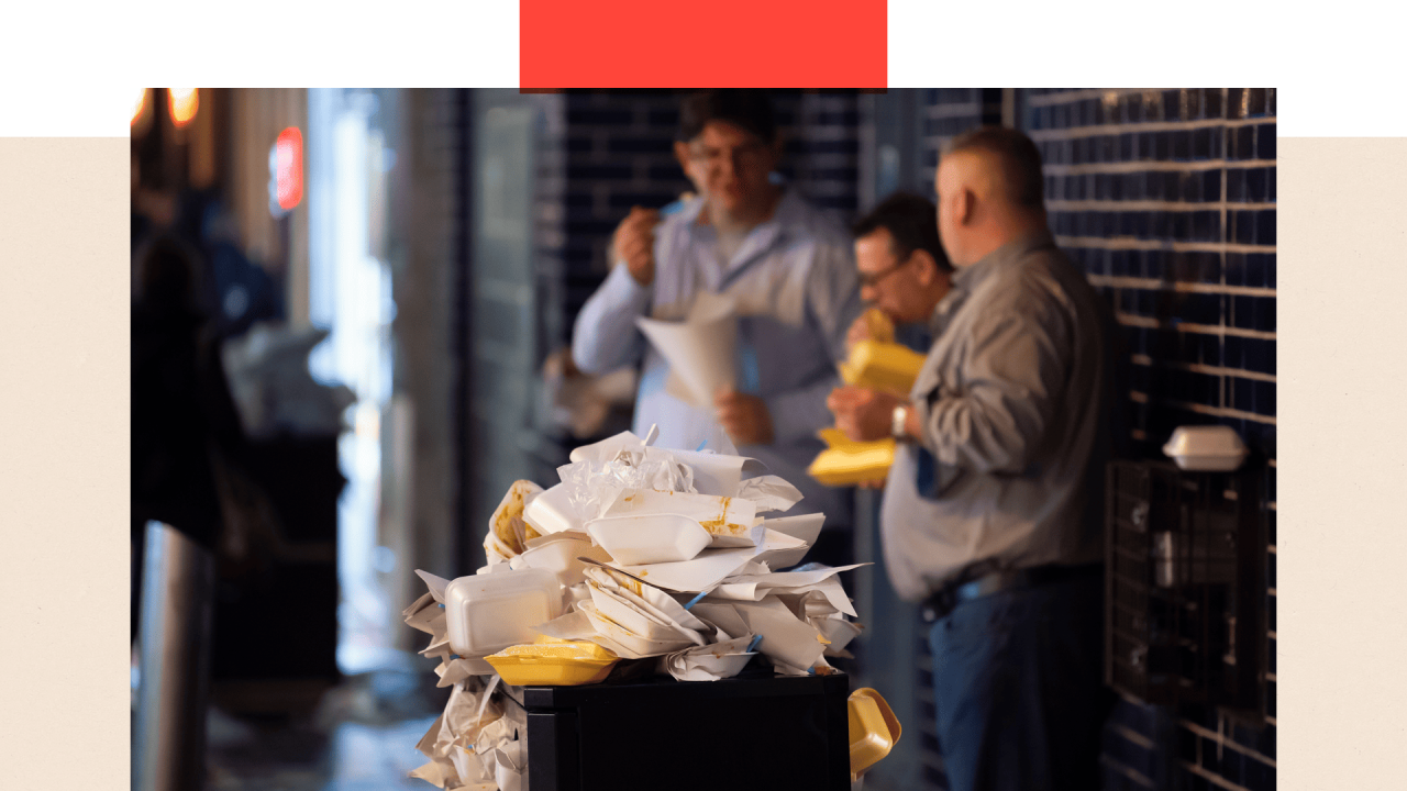 Kanta puna papira kojom je uvijena brza hrana,  u daljini troje ljudi jede 