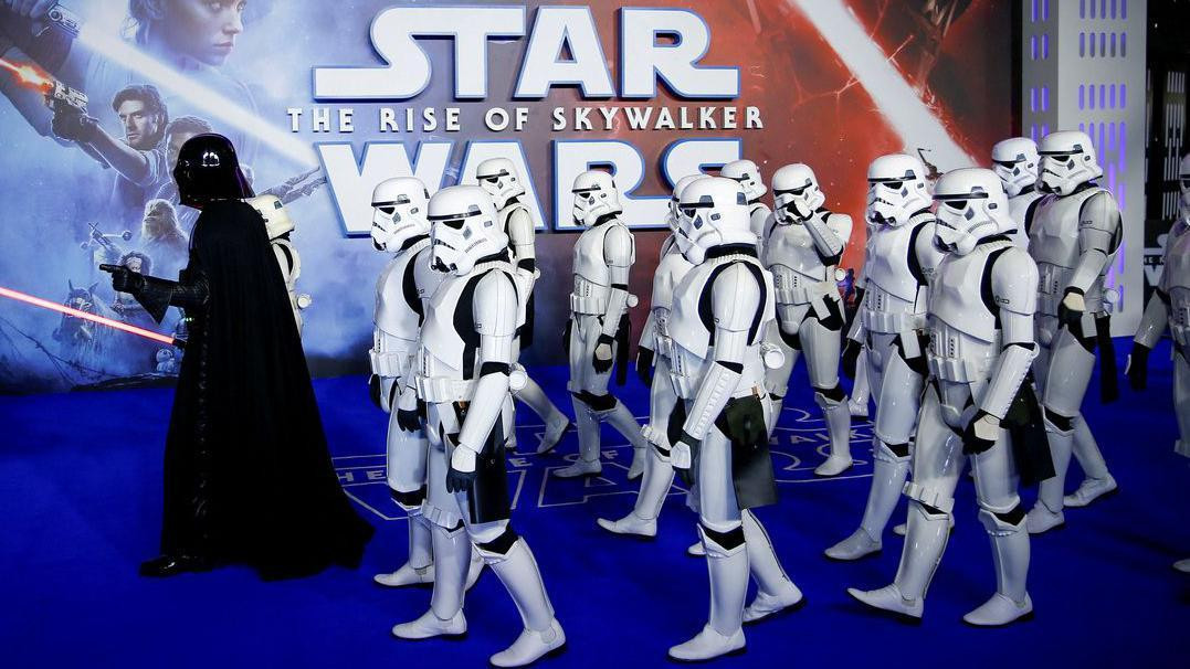 Ljudi u kostimima junaka filma Star Wars koje predvodi muškarac u crnom dugom plaštu