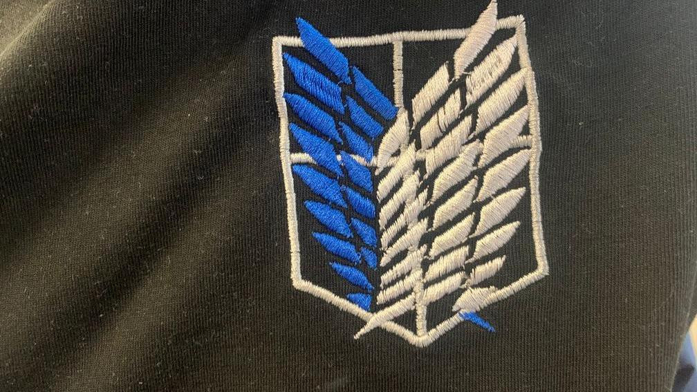 Plavo-beli znak iz anime serije na crnoj majici