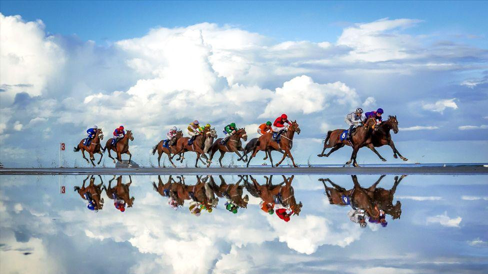 Odraz konja i džokeja u pesku u Lejtaunu, jedinoj konjskoj trci u Irskoj koja se održava na plaži 