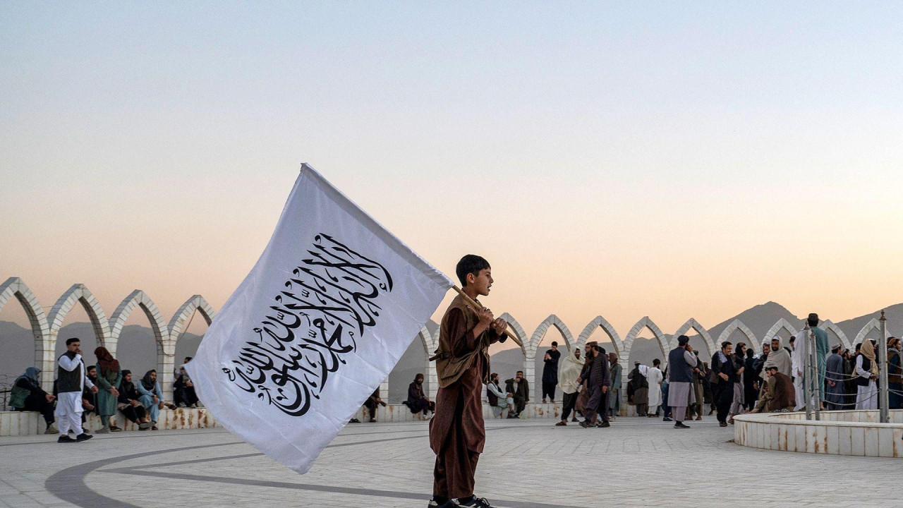 avganistanski dečak nosi zastavu talibana dok kliza preko vrha brda Vazir Akbar Kan u Kabulu 13. oktobra 2025. godine