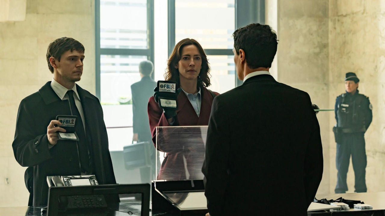 Evan Peters i Rebeka Hol pokazuju FBI legitimacije pred nepoznatim muškarcem; Peters u klasičnoj košulji i saku, Hol u crvenom saku i košulji.