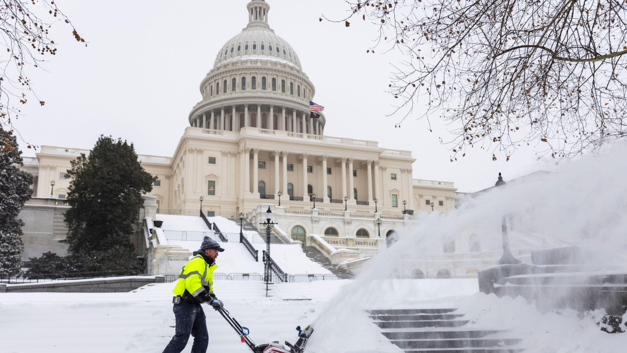službeno lice čisti sneg uz pomoć mašine za čišćenje snega ispred zgrade Kapitola u Vašingtonu 