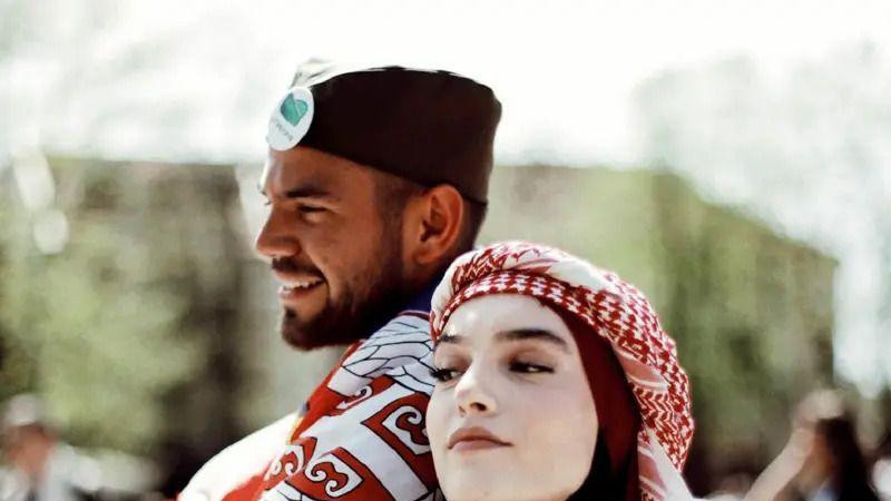 Devojka sa hidžabom na glavi i muškarac sa srpskom šajkačom na glavi