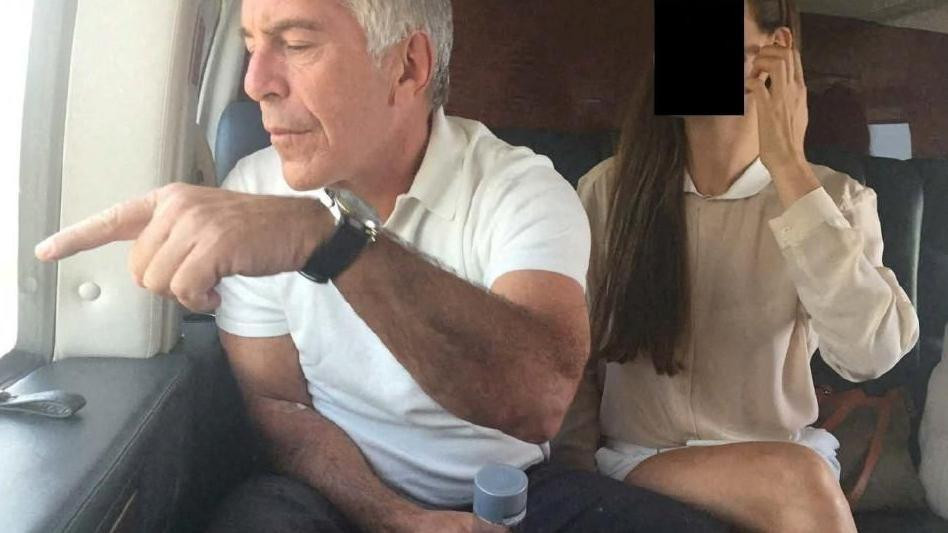 epstin i devojka čije se lice ne vidi sede u avionu, epstin joj nešto pokazuje prstom kroz prozor